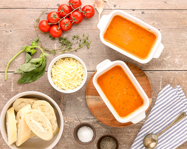 Tomato Soup in 5 inch rectangle white souper cubes baking dishes with cheese and bread ready to top