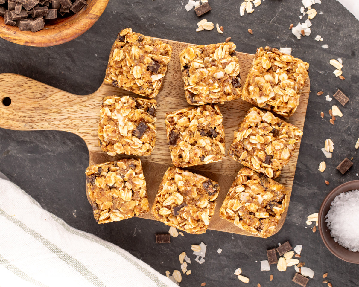 No-Bake Chocolate Oat Energy Bites (Freezer-Friendly) on a wood board with chocolate and sea salt