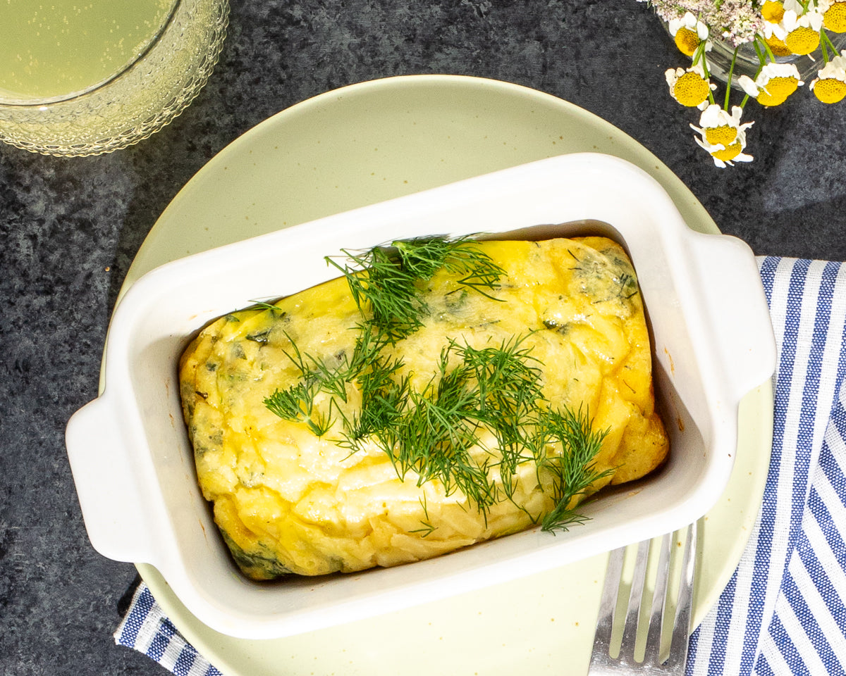 crustless quiches baked in Souper Cubes silicone trays, garnished with herbs in Souper Cubes White Ceramic Baking Dish