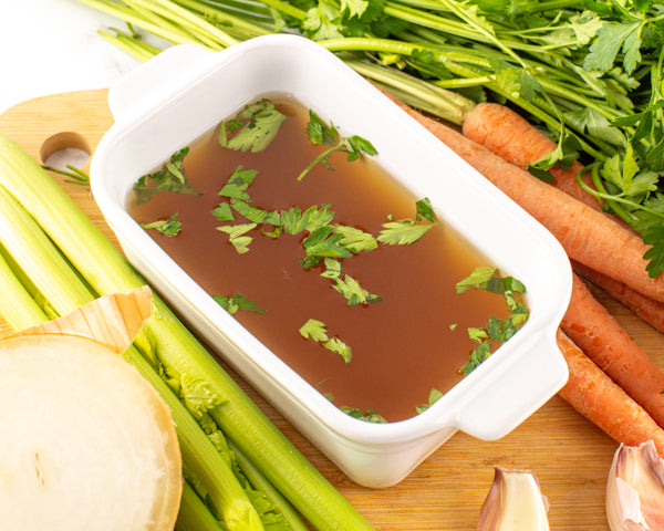 Close up photo of broth with vegetables around