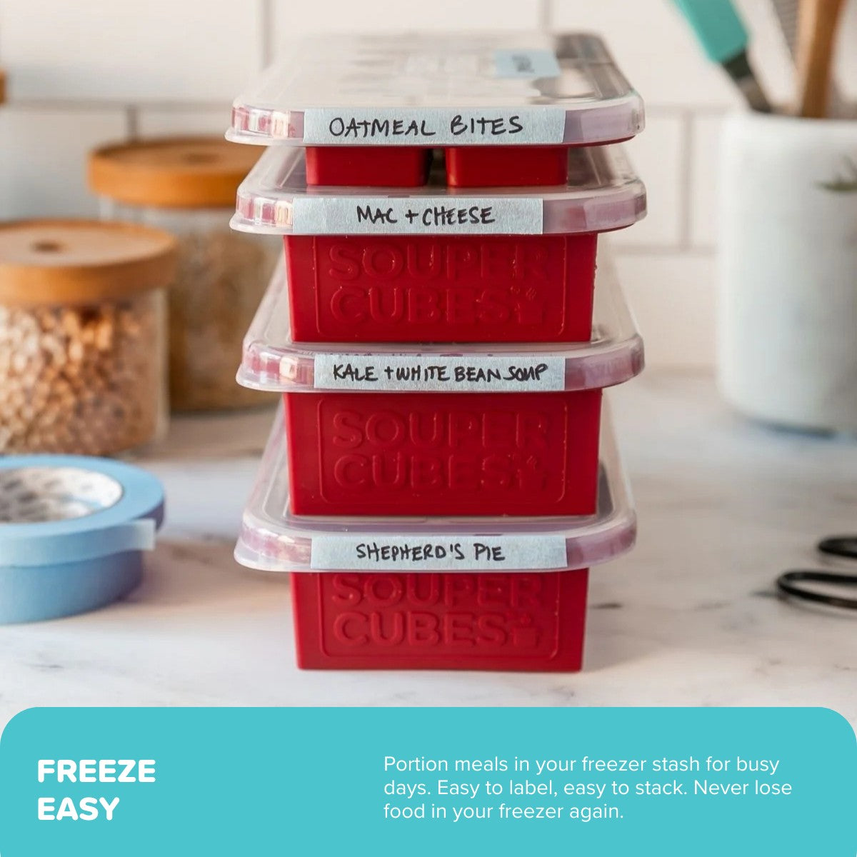Stack of cranberry Souper Cubes trays with labels on a kitchen counter.