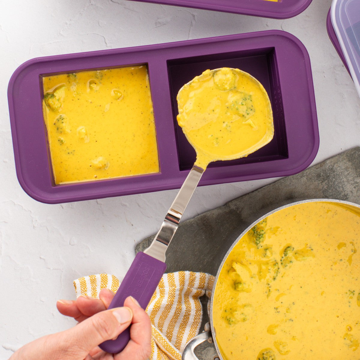 Plum freezer tray with a Souper Cubes ladle in use